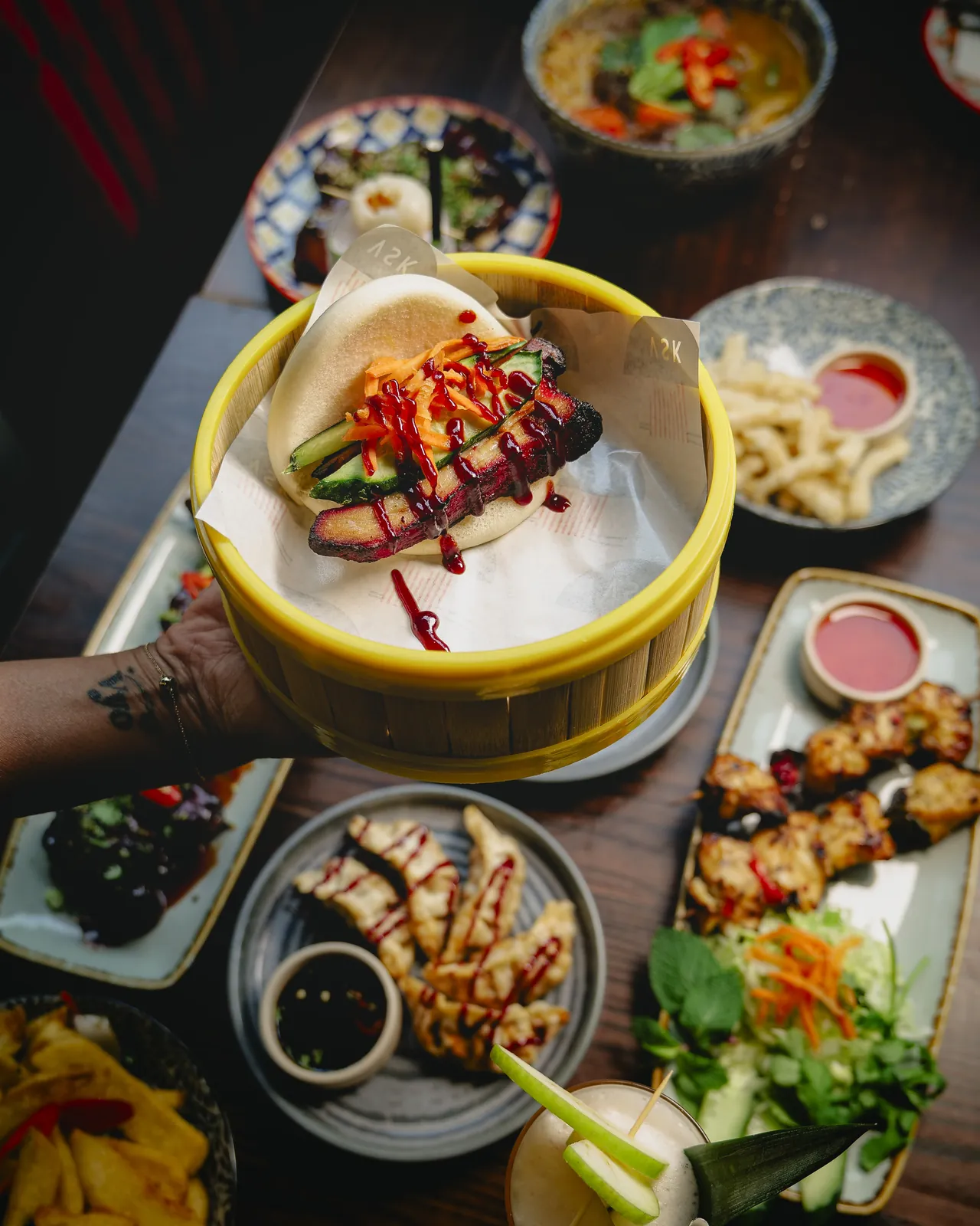 Roast pork bao bun held in hand at Vietnamese Street Kitchen Birmingham — steamed bun with roast pork, pickles and hoisin