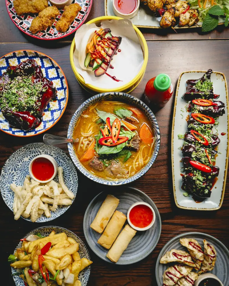 A sharing spread of Vietnamese street food at Vietnamese Street Kitchen Birmingham — bao buns, summer rolls and pho